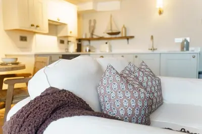 a white couch with pillows on it in a kitchen at The Little Lobster in Porthleven