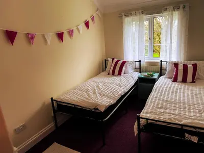 two beds in a room with flags on the wall at Countryside Converted Barn and Cottages Near Newquay in Saint Enoder