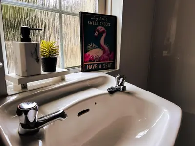 a bathroom sink with a book on the window at Countryside Converted Barn and Cottages Near Newquay in Saint Enoder