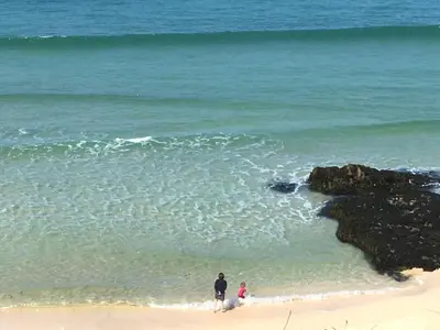two people standing on the beach near the ocean at The Stable Near St Ives Beaches Dog Friendly in St Ives
