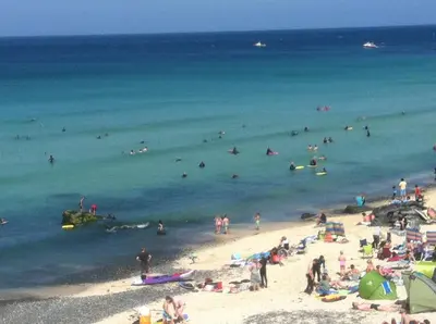 a group of people on a beach in the water at The Stable Near St Ives Beaches Dog Friendly in St Ives