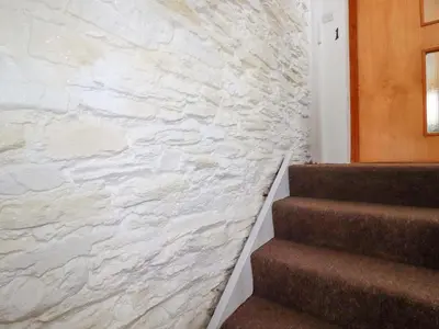 a staircase with a stone wall next to a stair case at Seaside Apartment in Looe