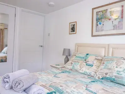 a bedroom with a bed with towels on it at The Penthouse in Looe