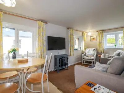 a living room with a couch and a table at The Penthouse in Looe
