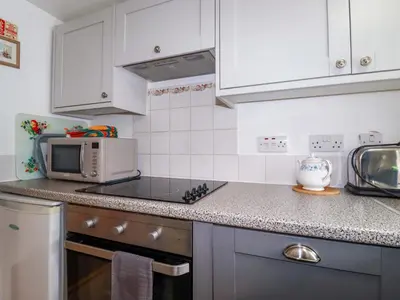 a kitchen with a microwave and a stove top oven at The Penthouse in Looe