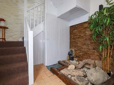 a room with a stone wall and stairs at The Penthouse in Looe