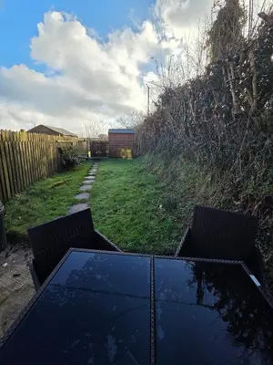 a table and chairs in a yard with a fence at Cosy Cornwall Cottage with Private Garden in Bodmin