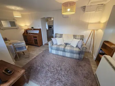 a living room with a couch and a table at Cosy Cornwall Cottage with Private Garden in Bodmin
