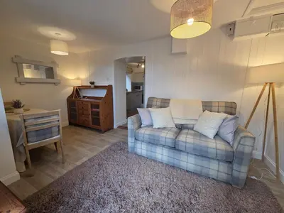 a living room with a couch and a table at Cosy Cornwall Cottage with Private Garden in Bodmin