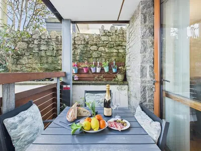 a table with a bottle of wine and a plate of fruit at 1 Arvor – Two-Bedroom Apartment with Parking at Maenporth Beach! Cornwall in Falmouth