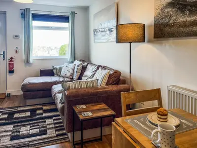 a living room with a couch and a table at Hillside in St Austell