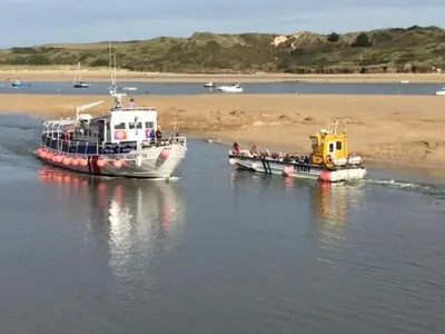 two boats in the water next to a beach at No 1 Exbury Padstow in Padstow
