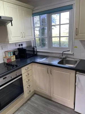 a kitchen with white cabinets and a sink at Cosy 3 bedroon chalet close to Hayle, 40 Tudor Court in Hayle