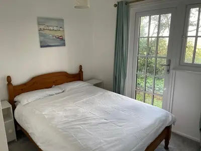 a bed in a bedroom with a large window at Cosy 3 bedroon chalet close to Hayle, 40 Tudor Court in Hayle