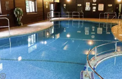 a large blue swimming pool in a building at Cosy 3 bedroon chalet close to Hayle, 40 Tudor Court in Hayle