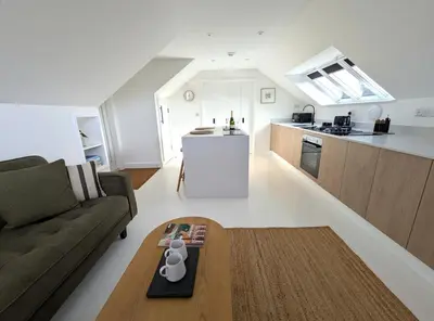 a living room with a couch and a table at Cober Riverside Retreat - Luxury Barn Apartment in The Heart of Cornwall in Wendron