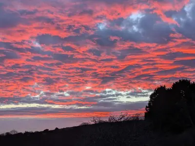 a sunset with red clouds in the sky at Cober Riverside Retreat - Luxury Barn Apartment in The Heart of Cornwall in Wendron
