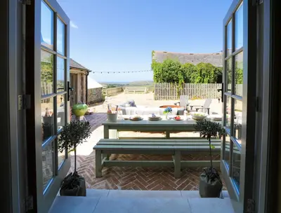 a view of a patio with a table and a couch at Bospebo Cottage in Camborne