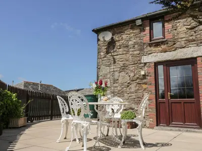 a patio with a table and chairs and a building at Applestore in Wadebridge