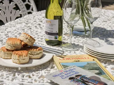 a table with a plate of food and a bottle of wine at Applestore in Wadebridge