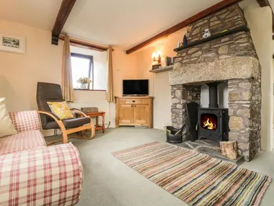 a living room with a stone fireplace and a couch at Applestore in Wadebridge