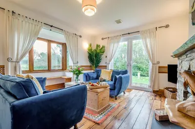 a living room with blue chairs and a fireplace at 2 Bed in Widemouth Bay oc-s34972 in Widemouth Bay