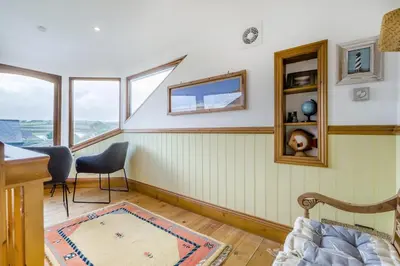 a room with a table and chairs and windows at 2 Bed in Widemouth Bay oc-s34972 in Widemouth Bay