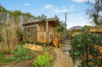 a small wooden house in a yard with a fence at 2 Bed in Widemouth Bay oc-s34972 in Widemouth Bay