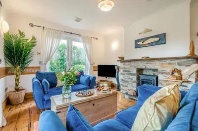 a living room with blue couches and a fireplace at 2 Bed in Widemouth Bay oc-s34972 in Widemouth Bay