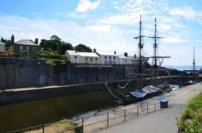 a boat is docked in a river next to a building at 4 Bed in St. Austell oc-t32965 in St Austell
