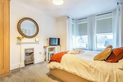 a bedroom with a bed with a fireplace and a mirror at 4 Bed in St. Austell oc-t32965 in St Austell