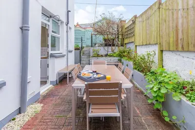 a patio with a wooden table and chairs at 4 Bed in St. Austell oc-t32965 in St Austell