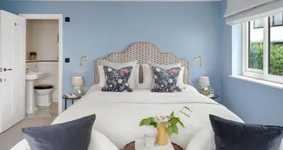 a bedroom with a large bed with blue walls at Luxury seaside home - 5 mins walk to beach - hot tub in Downderry