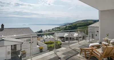 a balcony with a view of the water at Luxury seaside home - 5 mins walk to beach - hot tub in Downderry
