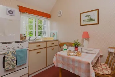 a kitchen with a table and a sink and a stove at Porthallow Lodge 350m to SWCP Talland Bay Retreat in Talland