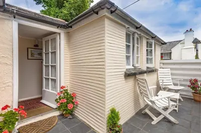 a small house with two chairs on a patio at Porthallow Lodge 350m to SWCP Talland Bay Retreat in Talland