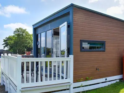 a tiny house with a wooden exterior and a white fence at Valley View - Uk50320 in Liskeard