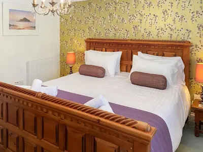 a bedroom with a large bed with two pillows at Dune Cottage - Uk48934 in Saint Erth