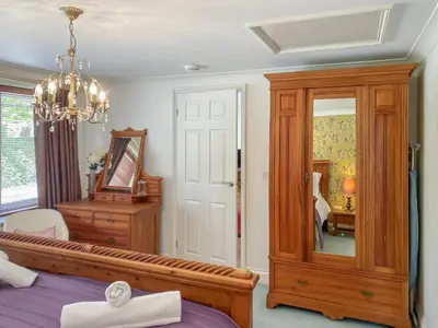 a bedroom with a bed and a dresser and a mirror at Dune Cottage - Uk48934 in Saint Erth