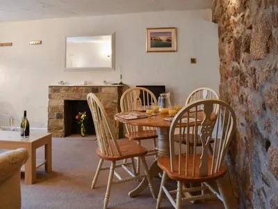 a dining room with a table and chairs and a fireplace at Henhouse - Uk49016 in Liskeard