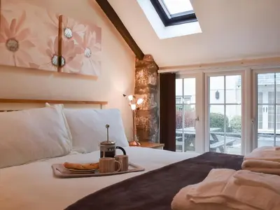 a bedroom with a bed with a tray of food on it at Henhouse - Uk49016 in Liskeard