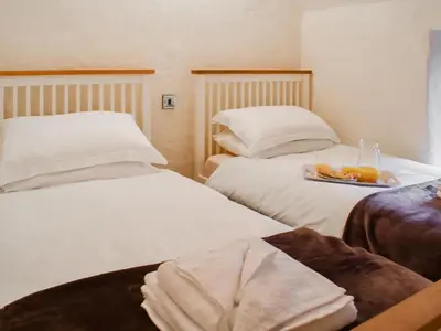 two beds in a hotel room with a tray of food at Haybarn - Uk49019 in Liskeard
