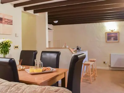 a dining room with a wooden table and black chairs at Haybarn - Uk49019 in Liskeard