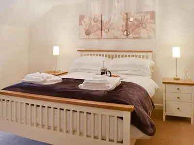 a bedroom with a large bed with towels on it at Haybarn - Uk49019 in Liskeard