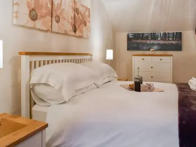 a bedroom with a white bed with a tray on it at Haybarn - Uk49019 in Liskeard