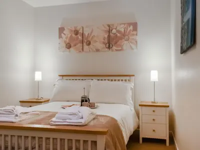 a bedroom with a bed with two night stands and two lamps at Milking Parlour - Uk49026 in Liskeard