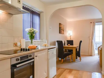a kitchen with a table with a vase of flowers at Milking Parlour - Uk49026 in Liskeard