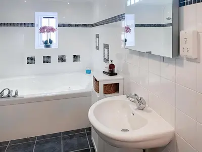 a white bathroom with a sink and a bath tub at Atlantic Cottage - Uk48935 in Saint Erth