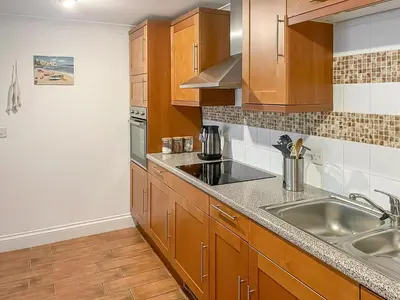 a kitchen with wooden cabinets and a sink at Atlantic Cottage - Uk48935 in Saint Erth