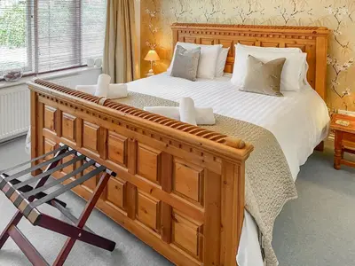 a bedroom with a large wooden bed and a chair at Atlantic Cottage - Uk48935 in Saint Erth